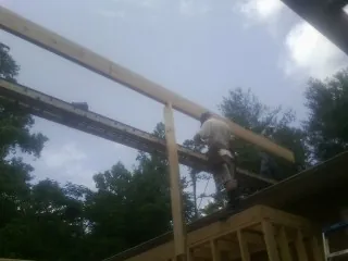 Carpenter setting a ridge beam over a new addition frame — Ice Dam Removal by Roofing Brothers in Peninsula