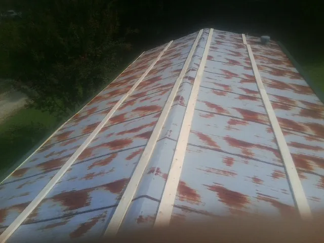 Rusted metal roof panels with new wood purlins before replacement — Storm Damage Roof Repair in Peninsula by Roofing Brothers
