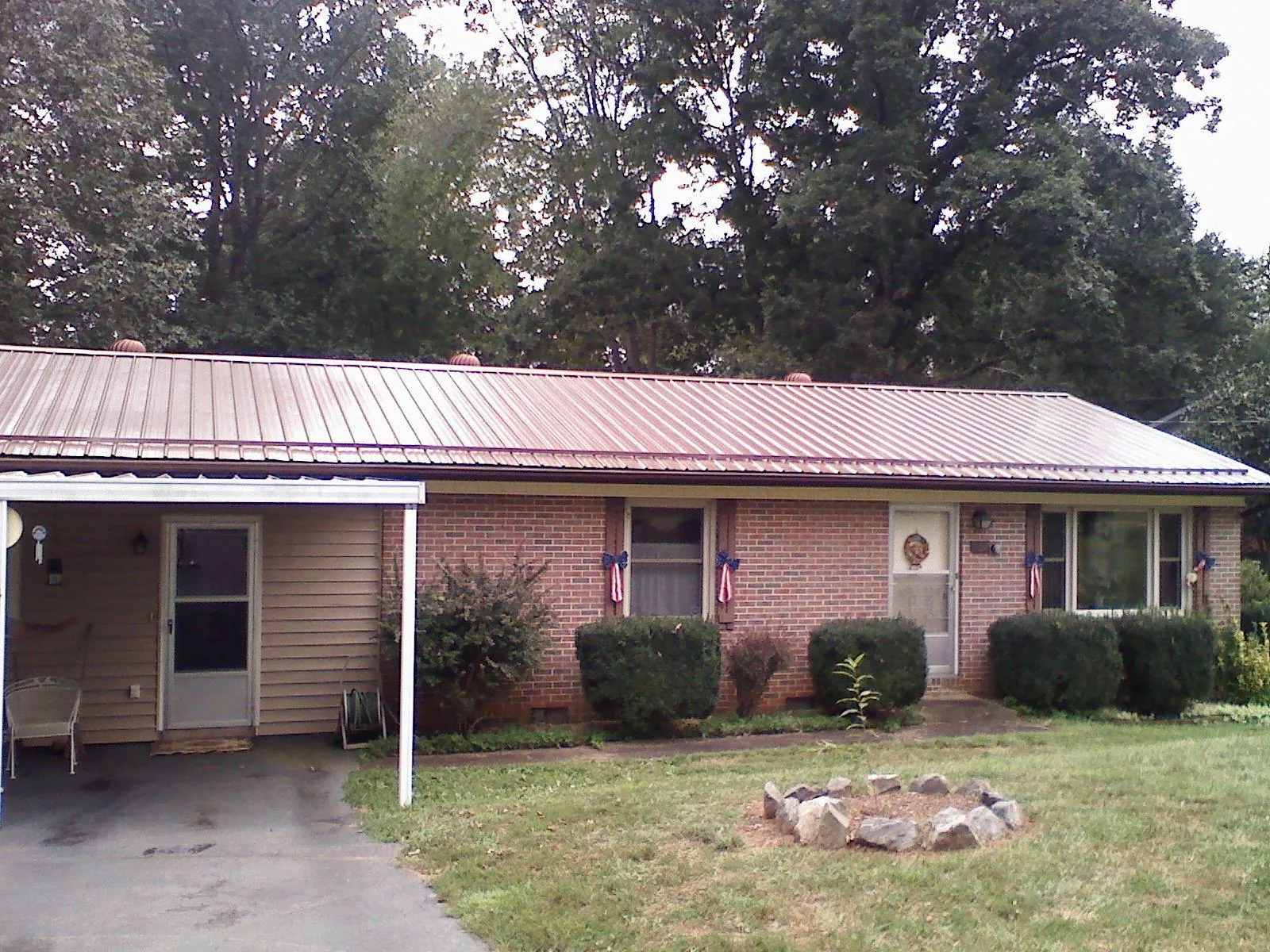 Bronze metal roof and carport on a brick ranch home — Roof Repair work by our crew in Peninsula